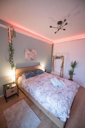 une chambre avec un lit avec deux oreillers dessus dans l'établissement JUNGLE ROOM évadez vous cosy luxe gare autoroute, à Givors
