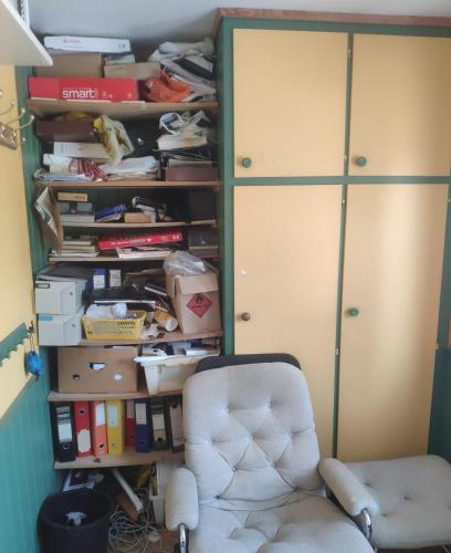 a room with a chair and a book shelf at Airbnb and Booking at Postvegen 95 in Vigra