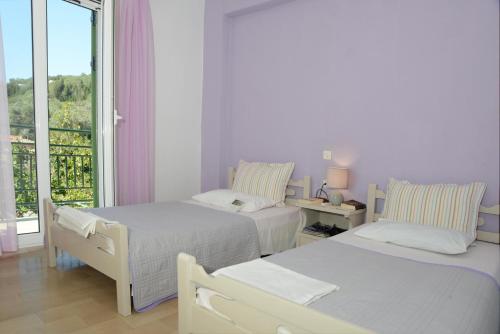 a white room with two beds and a window at Penelope - LOGGOS APARTMENTS in Longós