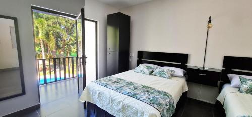 a bedroom with a bed and a large window at Hotel Green Jacó in Jacó