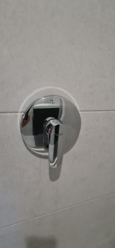 a toilet paper dispenser on a white wall at Hotel Green Jacó in Jacó