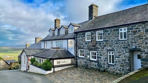 an old stone house with white windows at Castle Cottage Inn in Harlech