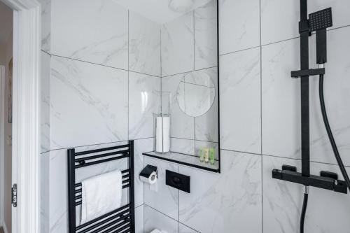 a white bathroom with a shower with a mirror at Dartford Kent Smart Nest in Dartford