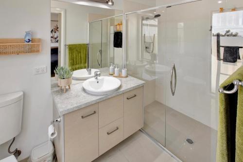 een witte badkamer met een wastafel en een douche bij Serenity Escapes in Paynesville