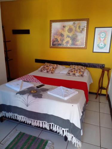 a bedroom with two beds and a painting on the wall at Recanto da Praia Rasa in Búzios