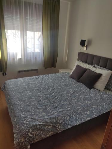 um quarto com uma cama grande e um cobertor azul em Apartman Vukajlović em Zlatibor