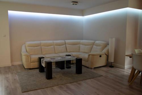 een woonkamer met een bank en een tafel bij Dom na Wynajem - Bartoszówka in Ochotnica Górna