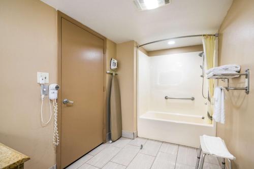 a bathroom with a shower and a tub at SureStay Plus Hotel by Best Western Poteau in Poteau