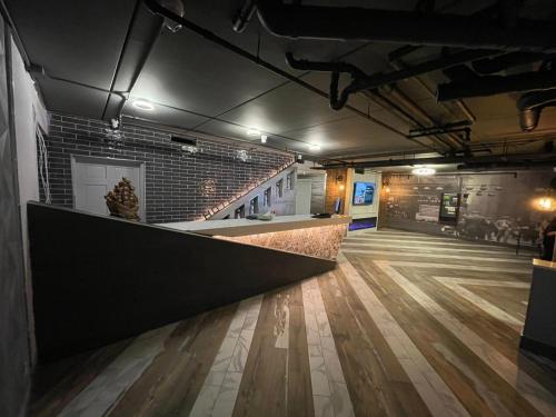 a bar in a room with a wooden floor at Casa Azul Hotel Blu-UBS Arena in Queens