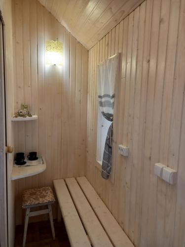 a room with a bench in a wooden wall at Три горішки in Yaremche