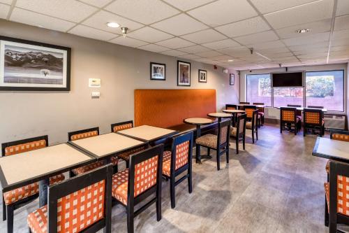a dining room with tables and chairs and a flat screen tv at SureStay Plus Hotel by Best Western Durham Medical Center in Durham