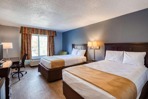 a hotel room with two beds and a desk at SureStay Plus Hotel by Best Western Durham Medical Center in Durham