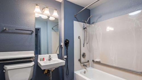 a bathroom with a sink and a toilet and a mirror at SureStay Plus Hotel by Best Western Durham Medical Center in Durham