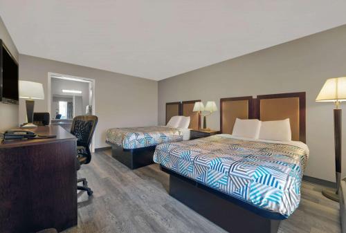 a hotel room with two beds and a desk at Motel 6 McDonough, GA in McDonough
