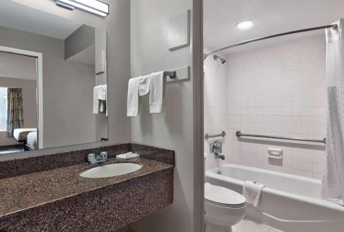 a bathroom with a sink and a toilet and a tub at Motel 6 McDonough, GA in McDonough