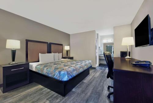 a hotel room with a bed and a desk and a computer at Motel 6 McDonough, GA in McDonough