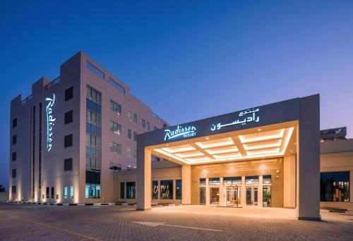 a large building with a large clock on the front of it at Radisson Resort Ras Al Khaimah Marjan Island in Ras al Khaimah