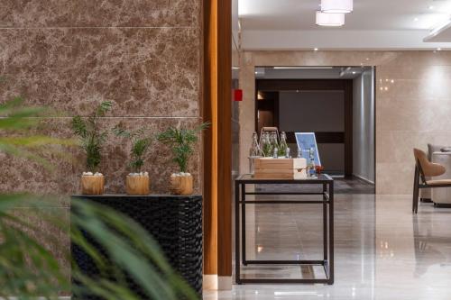a lobby with a table with plants on it at Radisson Resort Ras Al Khaimah Marjan Island in Ras al Khaimah