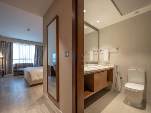 uma casa de banho com um WC, um lavatório e um espelho. em Radisson Resort Ras Al Khaimah Marjan Island em Ras al-Khaimah