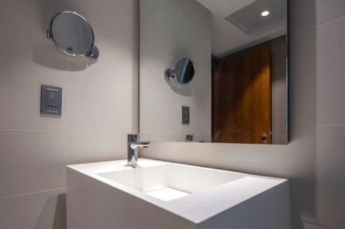 a bathroom with a white sink and a mirror at Radisson Resort Ras Al Khaimah Marjan Island in Ras al Khaimah