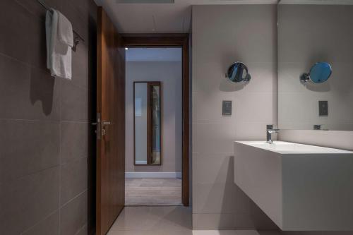 a bathroom with a white sink and a mirror at Radisson Resort Ras Al Khaimah Marjan Island in Ras al Khaimah