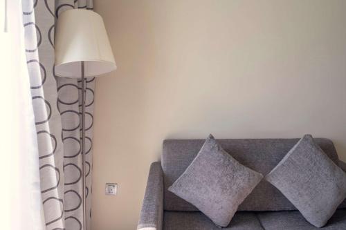 a living room with a couch with pillows and a lamp at Radisson Resort Ras Al Khaimah Marjan Island in Ras al Khaimah