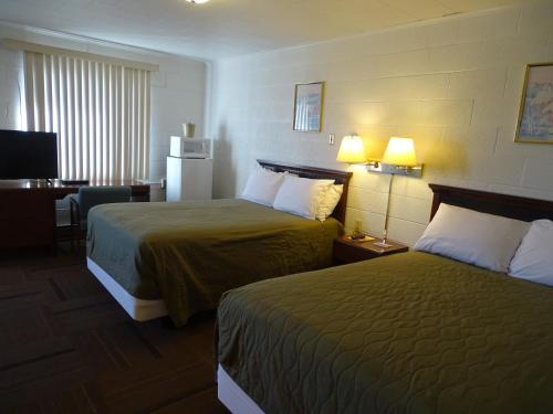 Habitación de hotel con 2 camas y escritorio en PRAIRIE WINDs MOTEL CARTHAGE, 