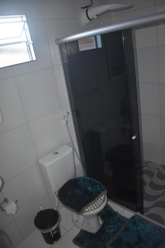 a bathroom with a shower and a toilet with a rug at Recanto Novo Horizonte in Recife