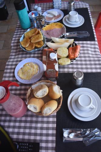 a table with plates of breakfast food on it at Recanto Novo Horizonte in Recife