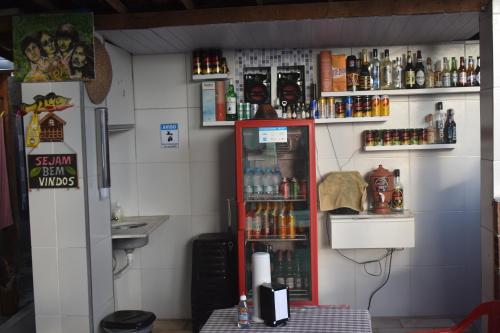 a room with a refrigerator and a counter with drinks at Recanto Novo Horizonte in Recife