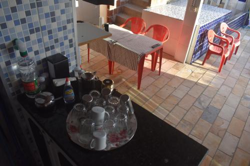 a kitchen with a counter with cups and a table with chairs at Recanto Novo Horizonte in Recife