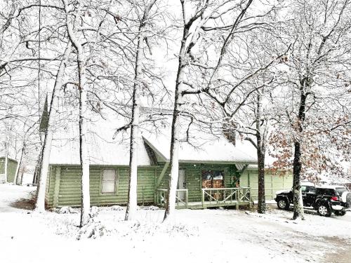 a snow covered house with a truck parked in front of it at Blufftop Cabin Retreat Hot Tub and Fall Views! in Canadian