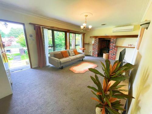 sala de estar con sofá y chimenea en Red sunny house en Rotorua
