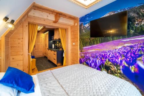 a bedroom with a mural of flowers on the wall at Chałpa u Zbójnika in Zakopane