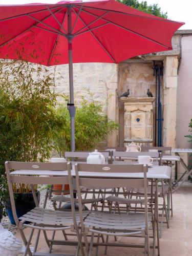 a red umbrella sitting on a table with chairs at Clos Saint Martin in Caen
