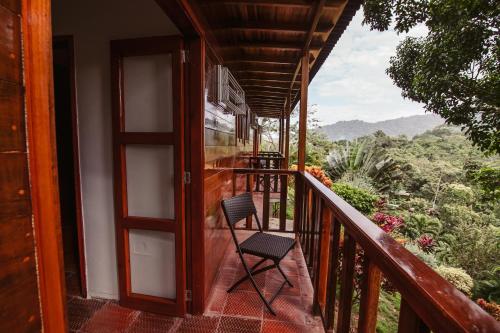 a chair sitting on a balcony with a view at Ecohotel Yachay Dentro del Parque Tayrona Inside Tayrona Park in El Zaino