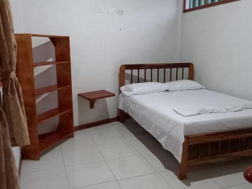 a bedroom with two beds and a book shelf at Hostal Zurymar Capurganá in Capurganá