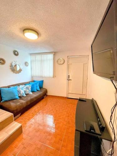 a living room with a couch and a flat screen tv at DEPTO FRENTE A ESTADIO GNP ANTES FORO SOL y AUTODROMO F1 A 10 MIN CAMINANDO in Mexico City