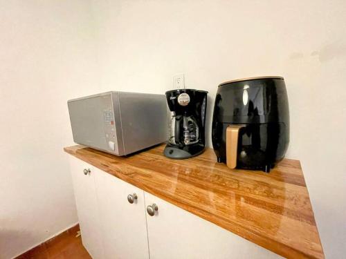 a kitchen counter with a coffee maker and a microwave at DEPTO FRENTE AL AUTODROMO HMNOS A 10 MIN CAMINANDO in Mexico City