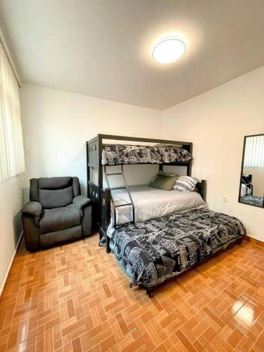 a bedroom with a bunk bed and a chair at DEPTO FRENTE A ESTADIO GNP ANTES FORO SOL y AUTODROMO F1 A 10 MIN CAMINANDO in Mexico City