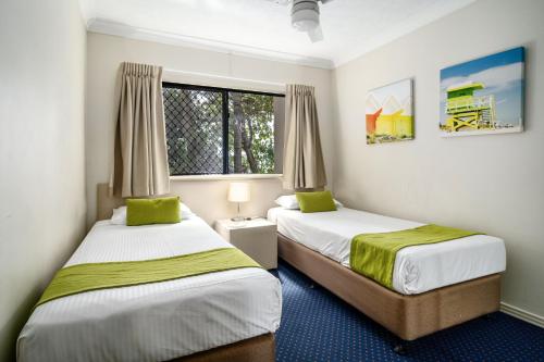 a bedroom with two beds and a window at Turtle Beach Resort in Gold Coast