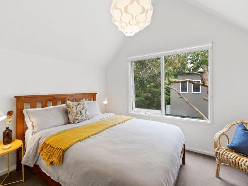 a white bedroom with a bed and a window at Point Roadknight Paradise Villa 6 in Anglesea