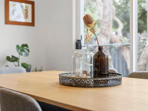 a vase with a flower in it on a table at Point Roadknight Paradise Villa 6 in Anglesea