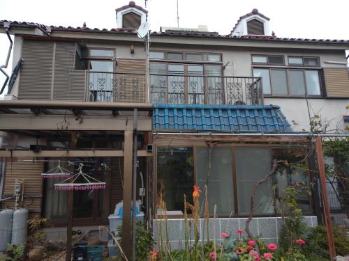 a house with a balcony on top of it at コウノトリの里の宿 in Fukiage