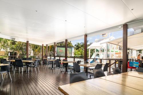a restaurant with tables and chairs and windows at Turtle Beach Resort in Gold Coast