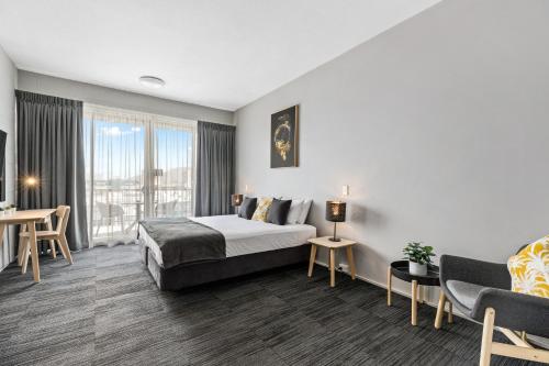 a hotel room with a bed and a desk at Gilligan's Hotel & Resort Cairns in Cairns
