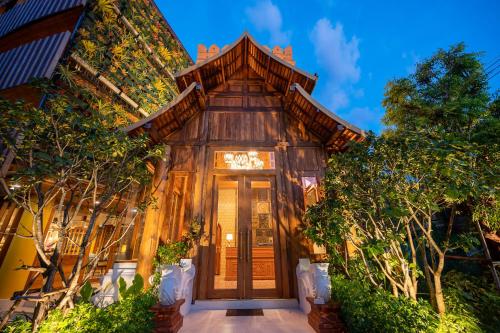 チェンマイにあるAt Gate Thaphae Hotelの木の玄関と木の家