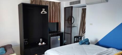 a bedroom with a black cabinet with a television at Hua Hin Paradise Guesthouse in Hua Hin