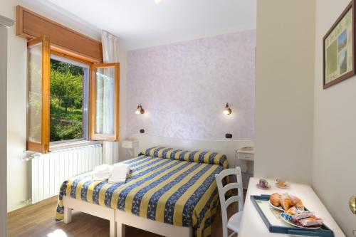 a small bedroom with a bed and a table and a window at Mamaral in Agerola