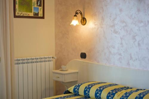 a bedroom with a bed and a light on the wall at Mamaral in Agerola
